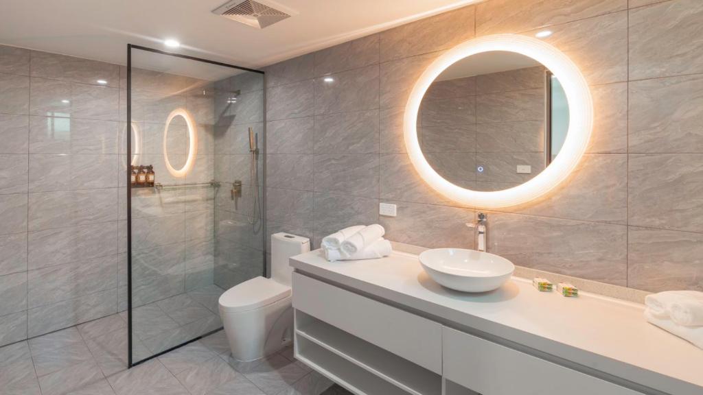 un bagno con lavandino, water e specchio di Hibiscus Suites And Residences a Nadi