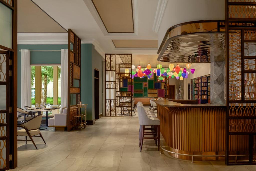 A richly decorated lobby lounge with a curved bar and library shelving.