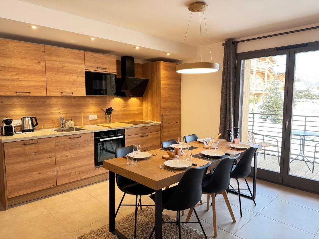 une salle à manger avec une table et des chaises dans une cuisine dans l'établissement Appartement moderne aux Gets avec parking et WIFI proche centre - FR-1-623-133, aux Gets