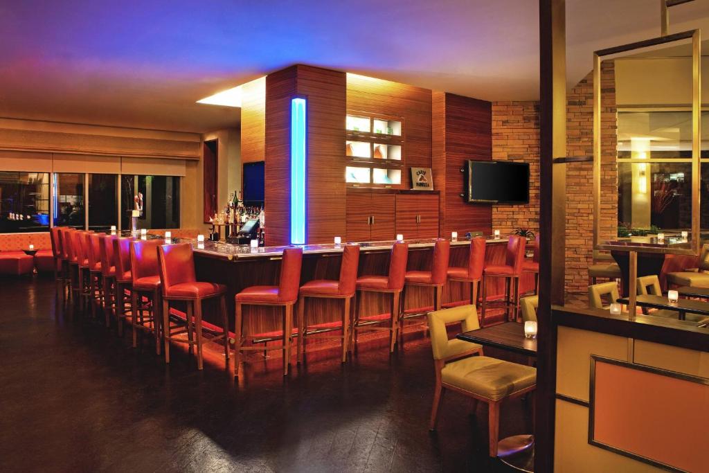 a bar in a restaurant with red chairs at The Westin Washington Dulles Airport in Herndon