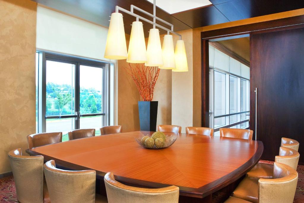 a dining room with a wooden table and chairs at The Westin Washington Dulles Airport in Herndon