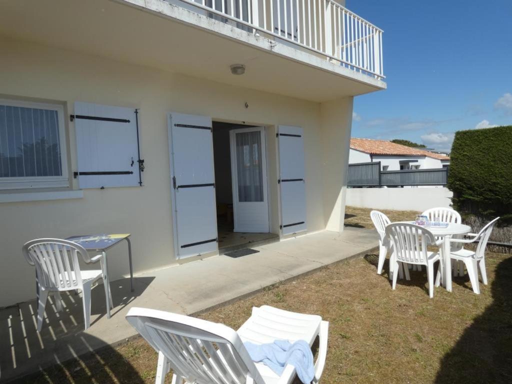 d'une terrasse avec des chaises blanches, une table et un balcon. dans l'établissement Appartement 39m², 1 chambre, animaux admis, parking, forêt, 5 pers - Notre-Dame-de-Monts - FR-1-540-297, à Notre-Dame-de-Monts