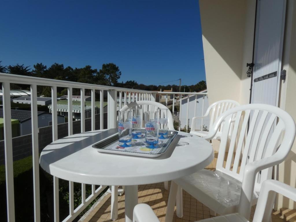 une table blanche et des chaises sur un balcon dans l'établissement Appartement 1 ch, 5 pers, forêt, animaux acceptés, parking - FR-1-540-301, à Notre-Dame-de-Monts