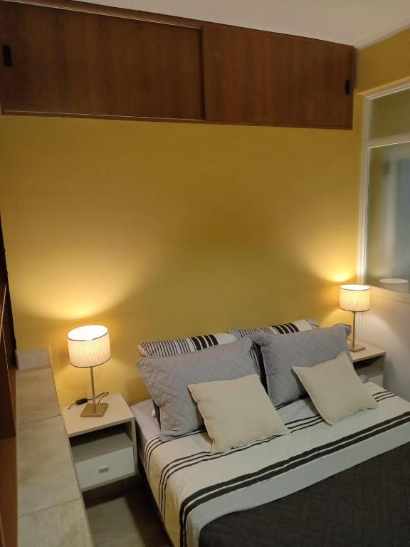 a bedroom with a large bed with two lamps on it at Departamento Letty I - Con Cochera in San Salvador de Jujuy