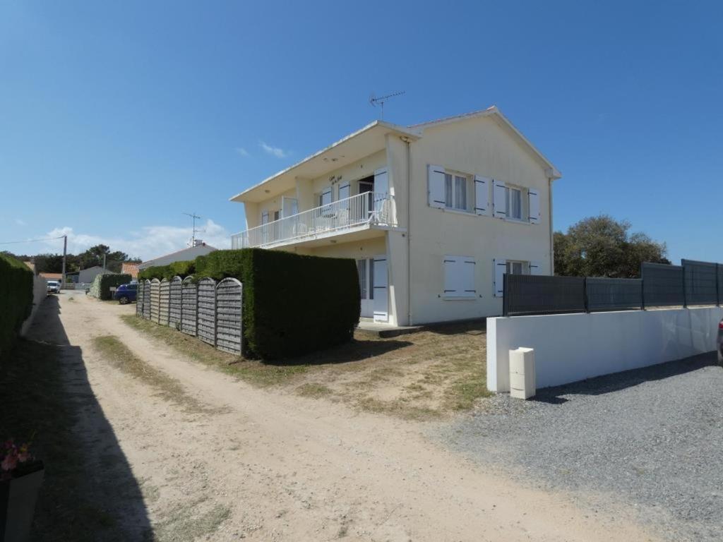 une maison blanche sur un chemin de terre avec une clôture dans l'établissement Appartement 39m² pour 5 pers, proche plage, parking, animaux admis - FR-1-540-296, à Notre-Dame-de-Monts