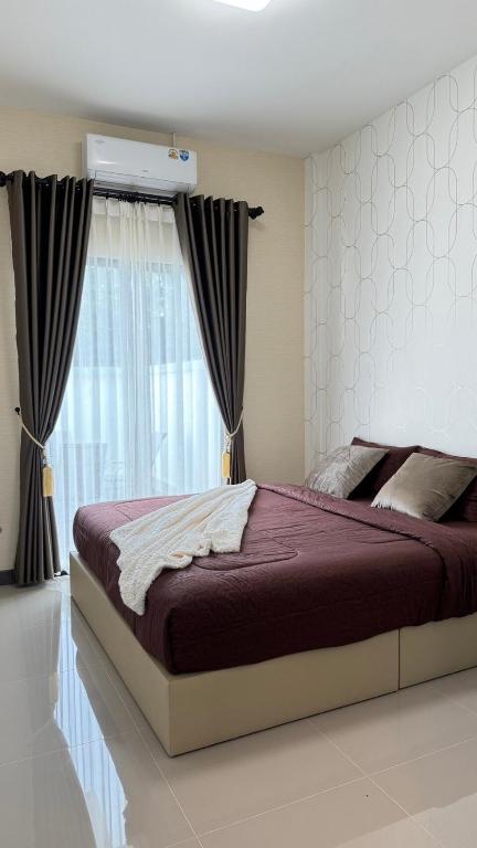 a large bed in a bedroom with a window at Vela House Songkhla in Songkhla