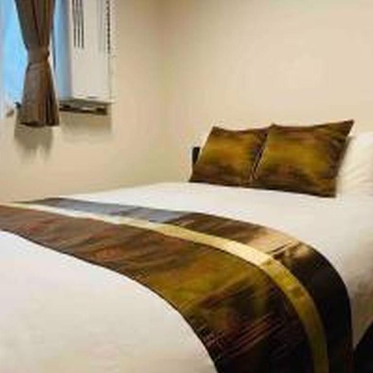 une chambre avec un lit avec un oreiller dessus dans l'établissement Alzate Uemachi 301 アルザーテ上町 301, à Osaka