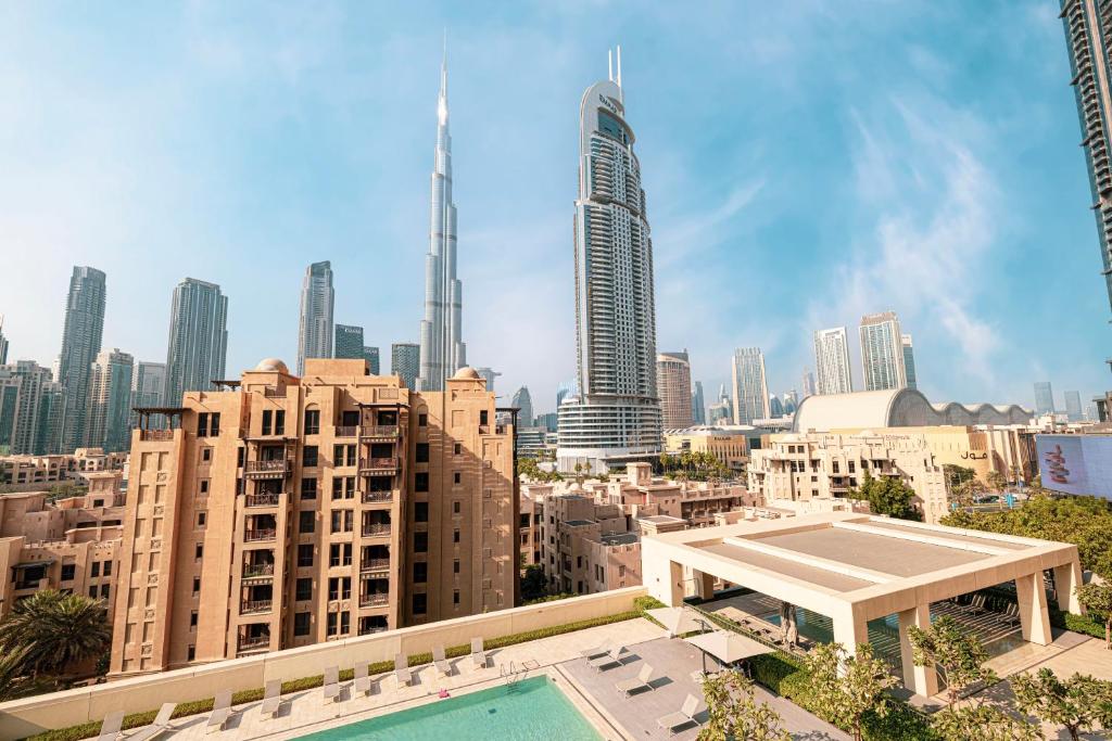 Hotel Full Burj Khalifa View! Brand New 2 Bedrooms! 5min walk From Dubai Mall!, a view of a city with a pool and buildings at Full Burj Khalifa View! Brand New 2 Bedrooms! 5min walk From Dubai Mall! in Dubai