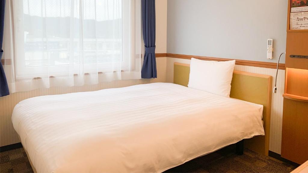 Postel nebo postele na pokoji v ubytování Toyoko Inn Tsuruga Ekimae