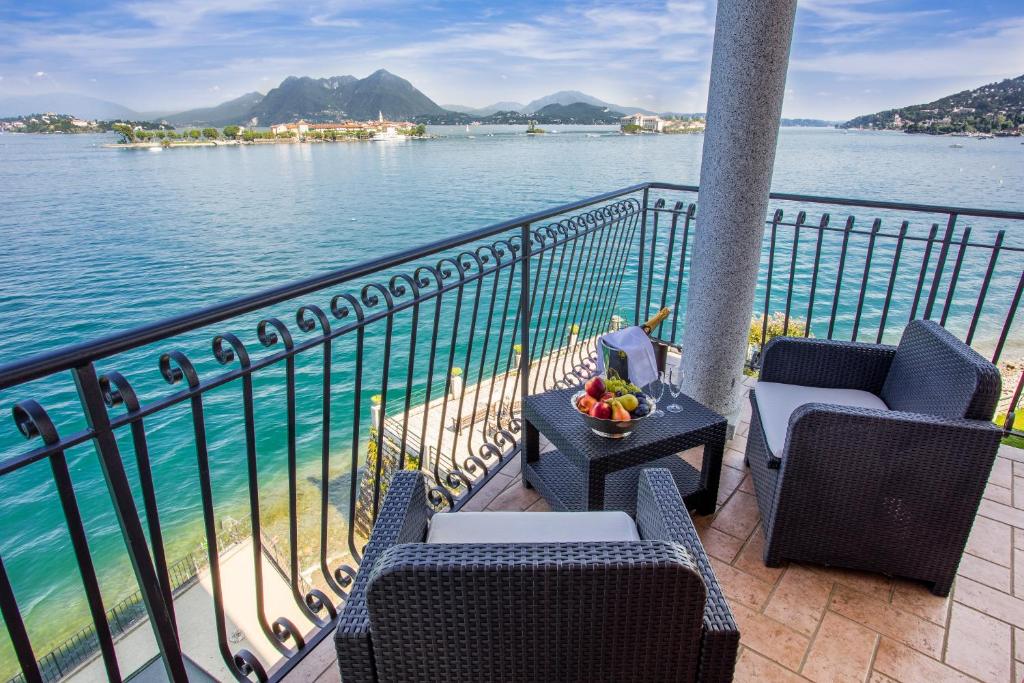 a balcony with chairs and a table with a view of the water at Hotel Romagna in Baveno