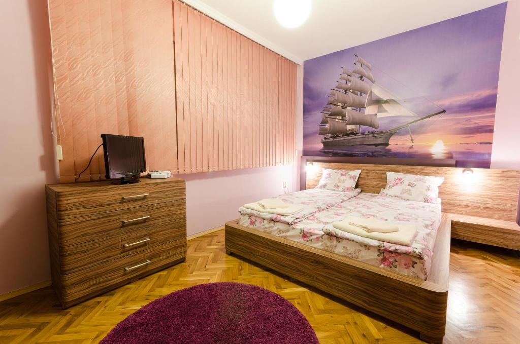ein Schlafzimmer mit einem Bett und einem Schiffsbild in der Unterkunft Sea Garden Plaza Apartment in Burgas City
