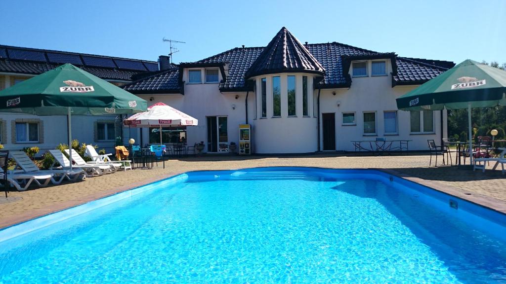 a swimming pool in front of a house at Brydar with Sauna, Swimming Pool and Jacuzzi in Mielno