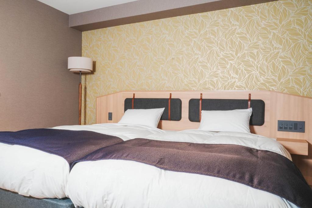 Postel nebo postele na pokoji v ubytování Kyoto Pleasant Hotel