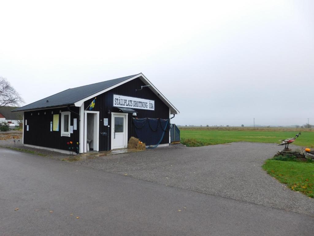 a black and white building with a sign on it at Drottning Ödas Boende in Degerhamn