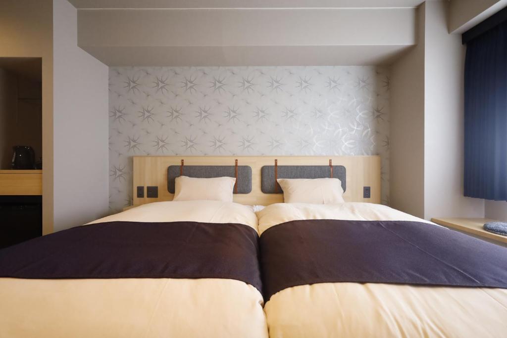 Postel nebo postele na pokoji v ubytování Kyoto Pleasant Hotel