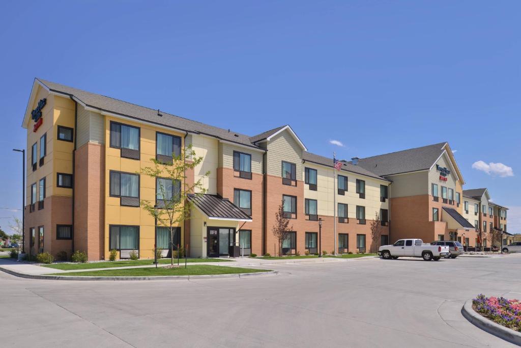 an apartment building with a car parked in a parking lot at TownePlace Suites by Marriott Gillette in Gillette