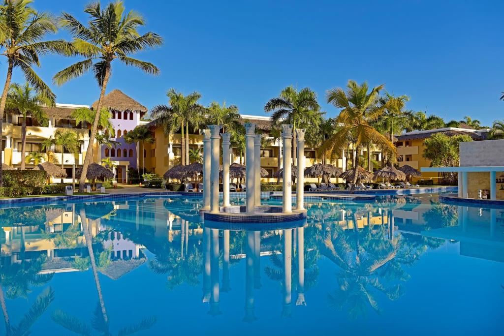 a pool at a resort with palm trees and buildings at Iberostar Costa Dorada in San Felipe de Puerto Plata