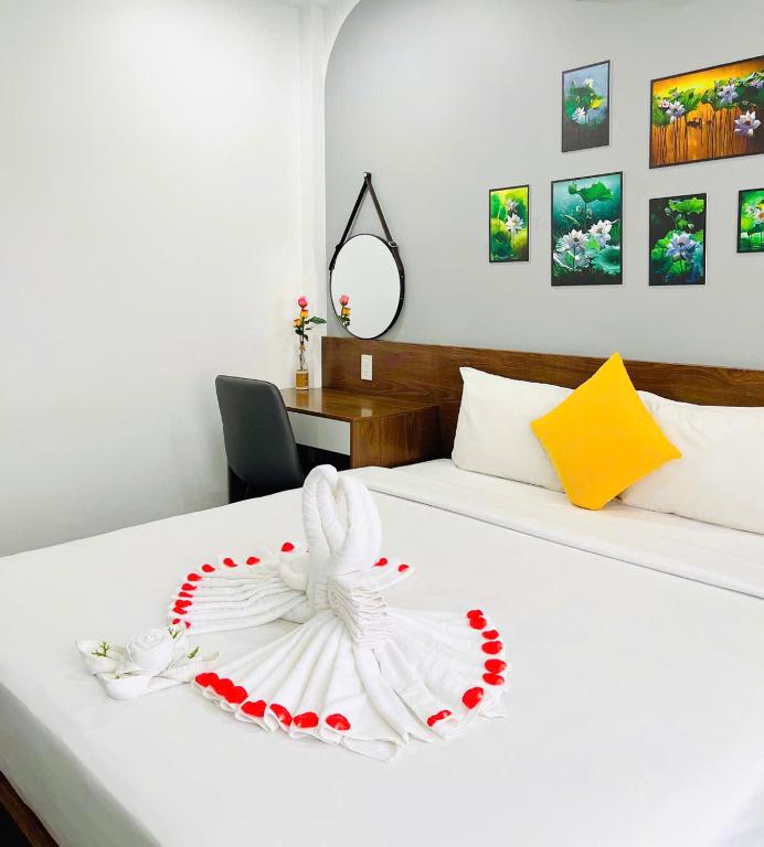 a bedroom with a white bed with a flower on it at Hue Royal Hotel in Hue