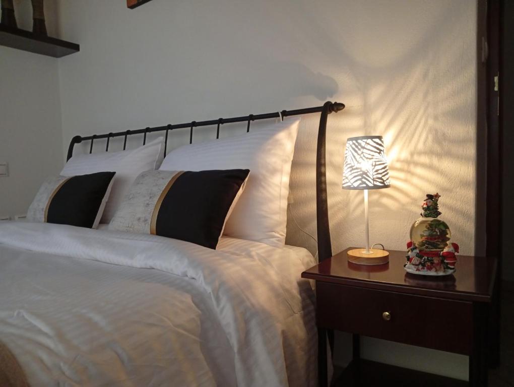 a bedroom with a bed with a lamp on a night stand at The Stoners apartment in Kalabaka