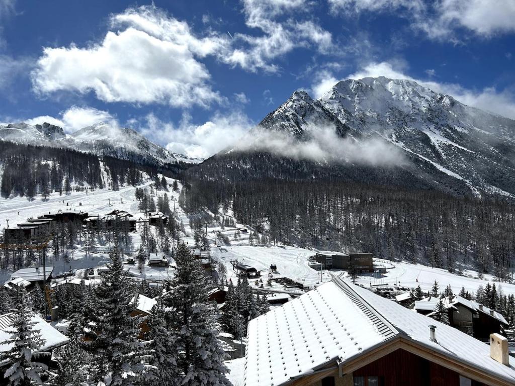 ein Skigebiet mit schneebedeckten Bergen im Hintergrund in der Unterkunft Les Marmottes in Montgenèvre