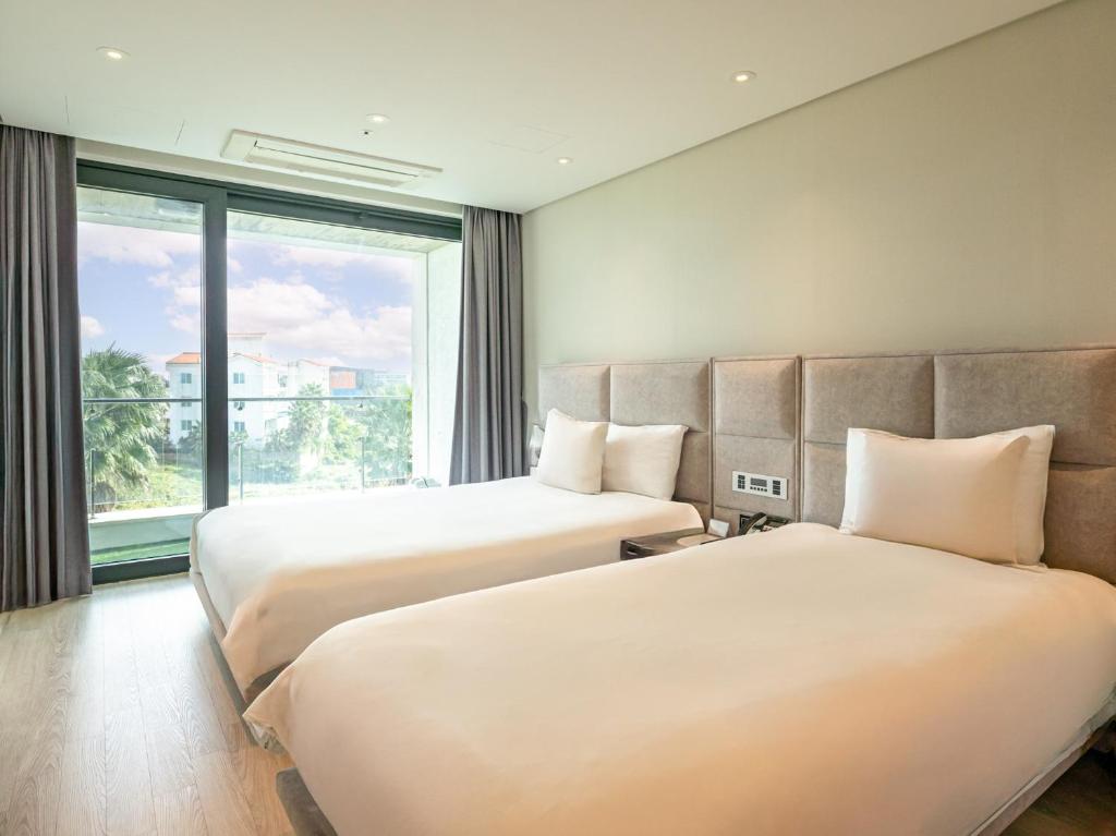 Postel nebo postele na pokoji v ubytování Jeju Attirance Hotel & poolvilla