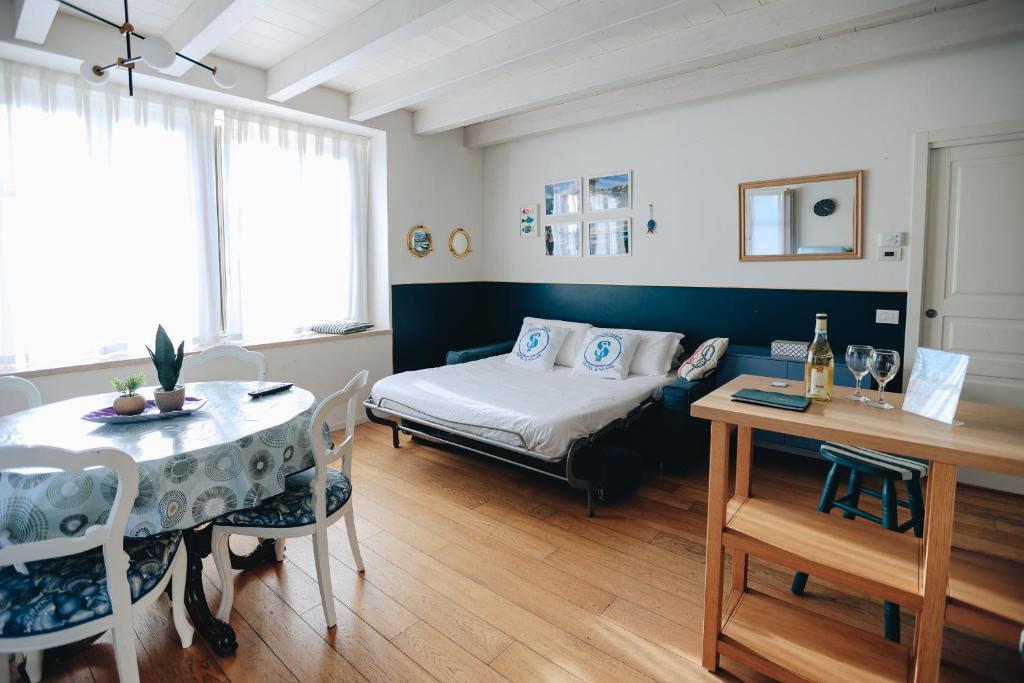 sypialnia z łóżkiem, stołem i krzesłami w obiekcie Ponte dei Voltoni Apartment w mieście Peschiera del Garda