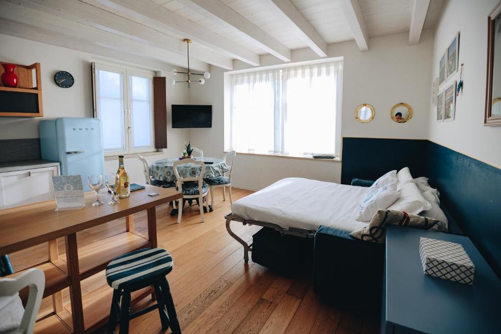 sypialnia z łóżkiem i biurkiem oraz jadalnia w obiekcie Ponte dei Voltoni Apartment w mieście Peschiera del Garda