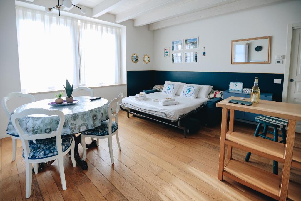 pokój z łóżkiem i stołem z krzesłami w obiekcie Ponte dei Voltoni Apartment w mieście Peschiera del Garda