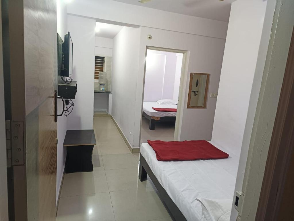 a small room with a bed and a mirror at SLV guest house in Bengaluru