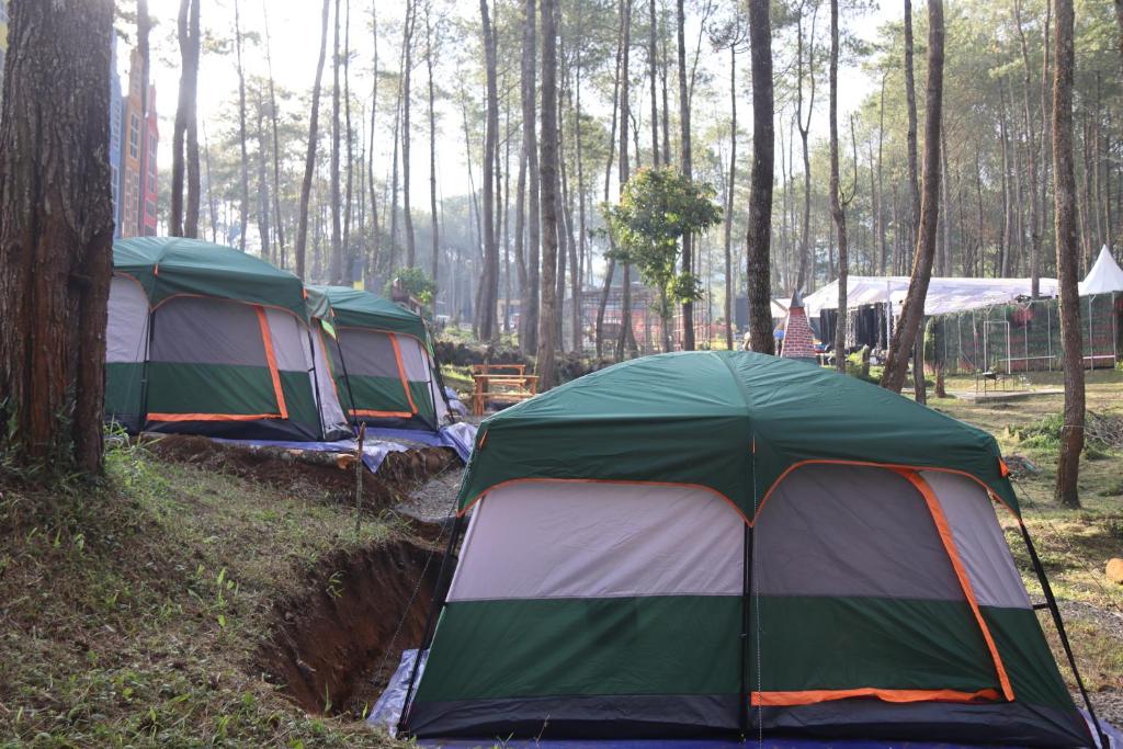 three tents are lined up in a forest at Great Panorama Lodge and Camp by MHM in Lembang