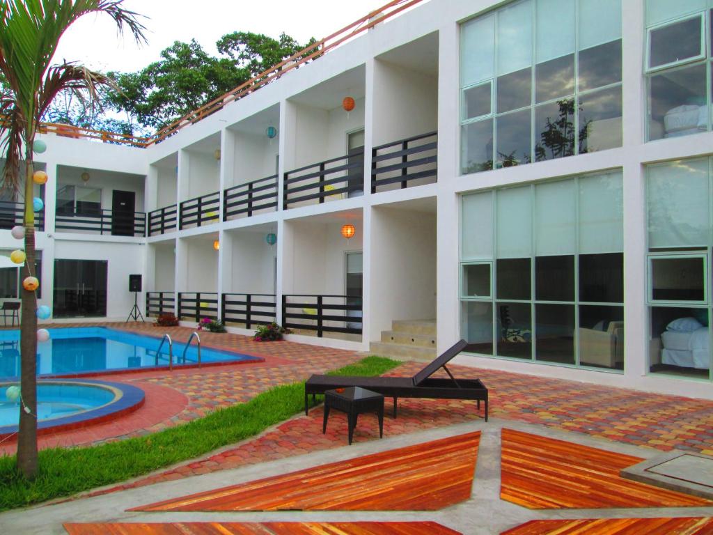 un edificio con una piscina y una mesa frente a ella en Ocean Blue Hotel, en Olón