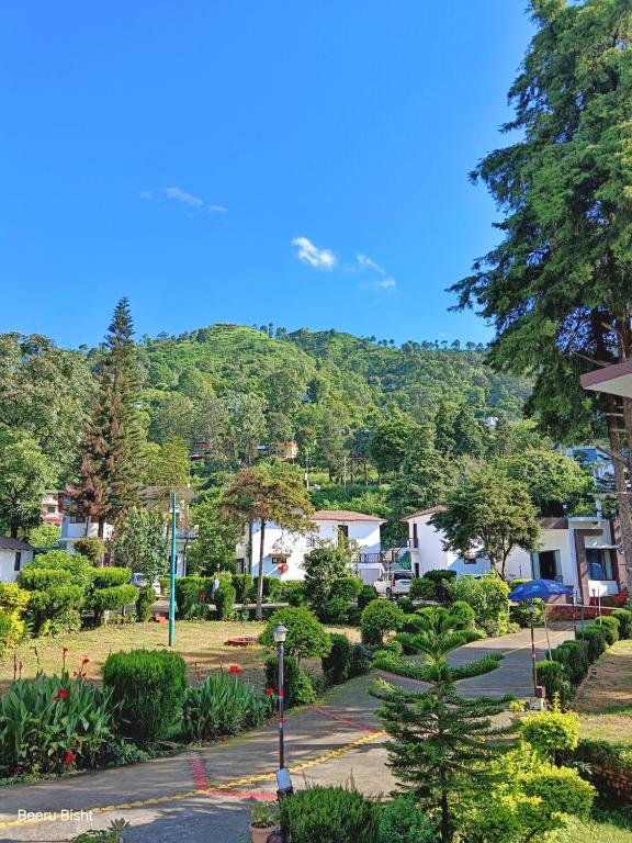 a view of a park with a mountain in the background at Shikha Resort Ewentbliz in Bhīm Tāl