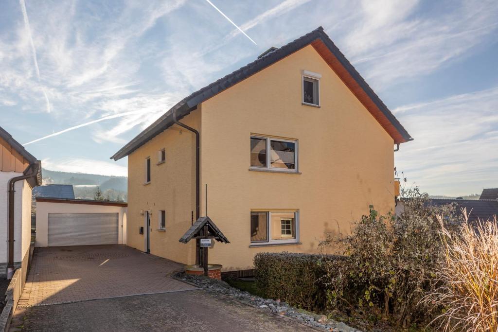 a house with a garage and a driveway at Ferienwohnung MiA in Frankenau