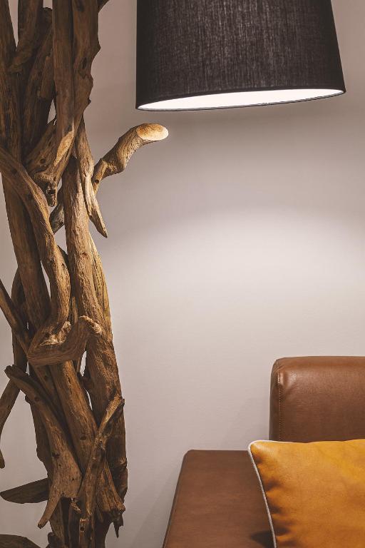 a lamp with a tree branch design next to a couch at Costa Rica Bibione SPA in Bibione