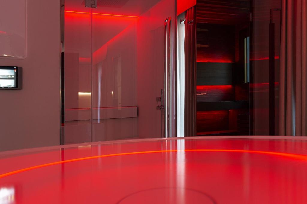 a red room with a glass table and red lights at Costa Rica Bibione SPA in Bibione