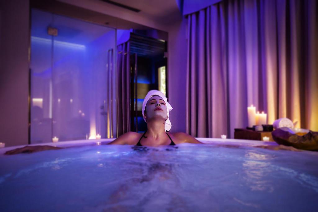 a woman in a bath tub in a room at Costa Rica Bibione SPA in Bibione