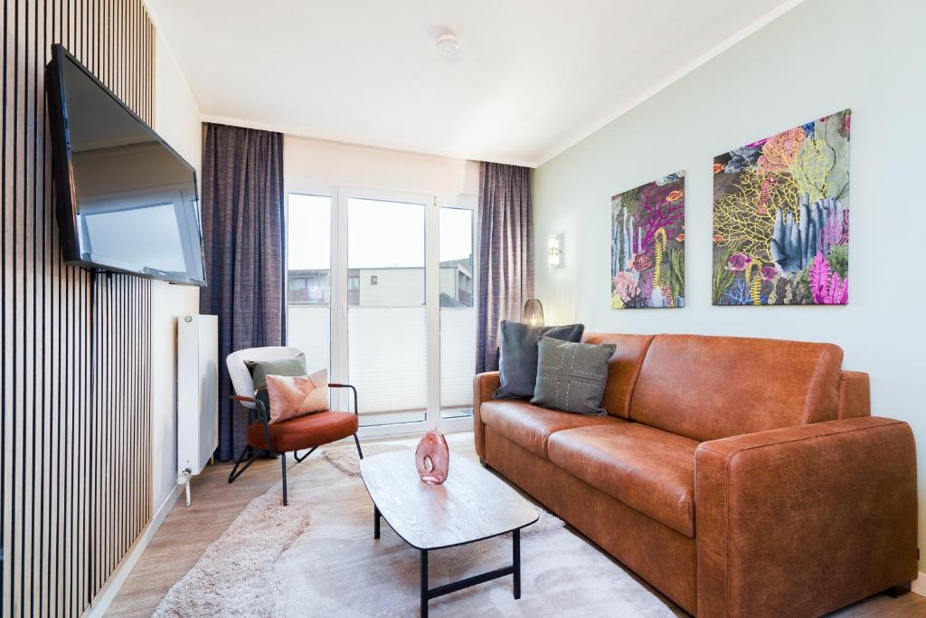 TV a/nebo společenská místnost v ubytování Das Solaris 3 Beach Apartment mit Balkon, Gemeinschaftssauna und Grillplatz