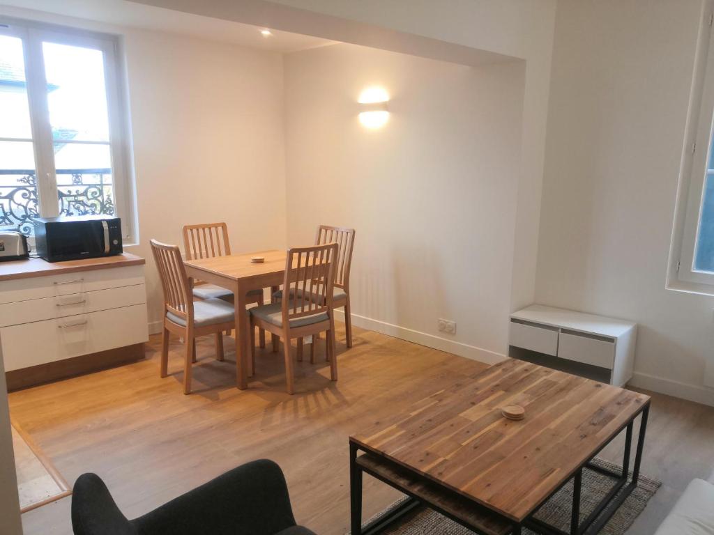 a dining room with a wooden table and chairs at 2P refait à neuf, calme, quartier historique, entre seine et cathédrale in Mantes-la-Jolie