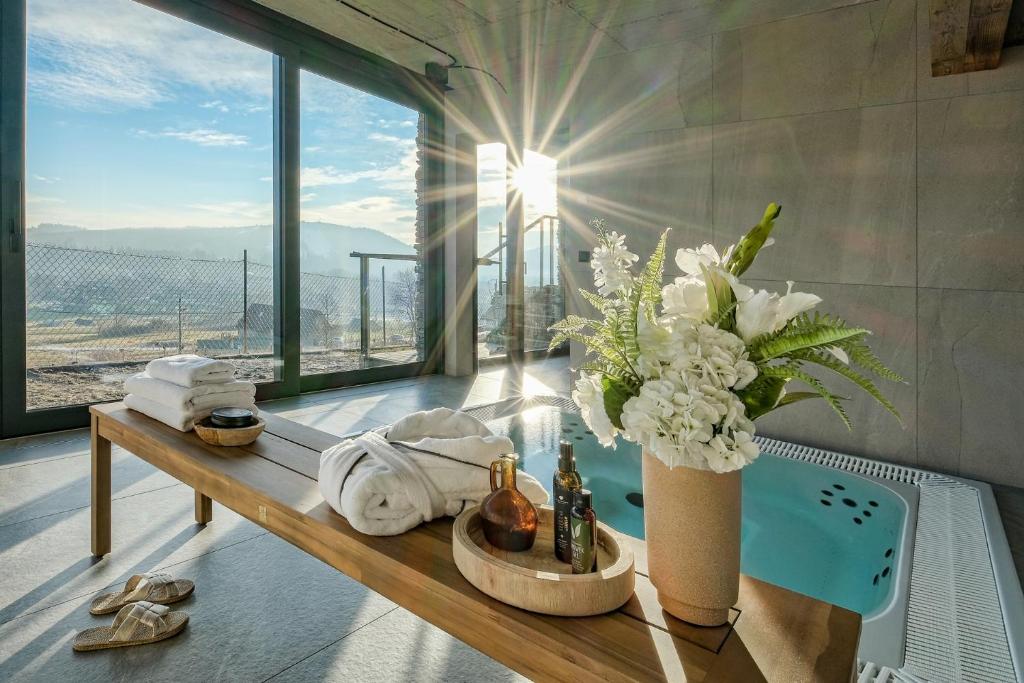 a bathroom with a tub with a vase of flowers at Rezydencja Słoneczna - SPA & Apartamenty z widokiem - blisko Term Bania, Odkryj-Bialke in Białka Tatrzańska