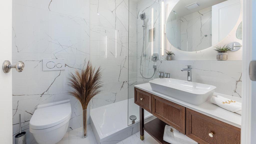 a bathroom with a sink and a toilet and a shower at Royal Neptun Hotel in Dubrovnik
