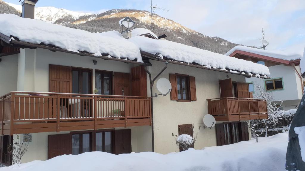 a building with snow on top of it at Appartamento in Val di Sole in Commezzadura