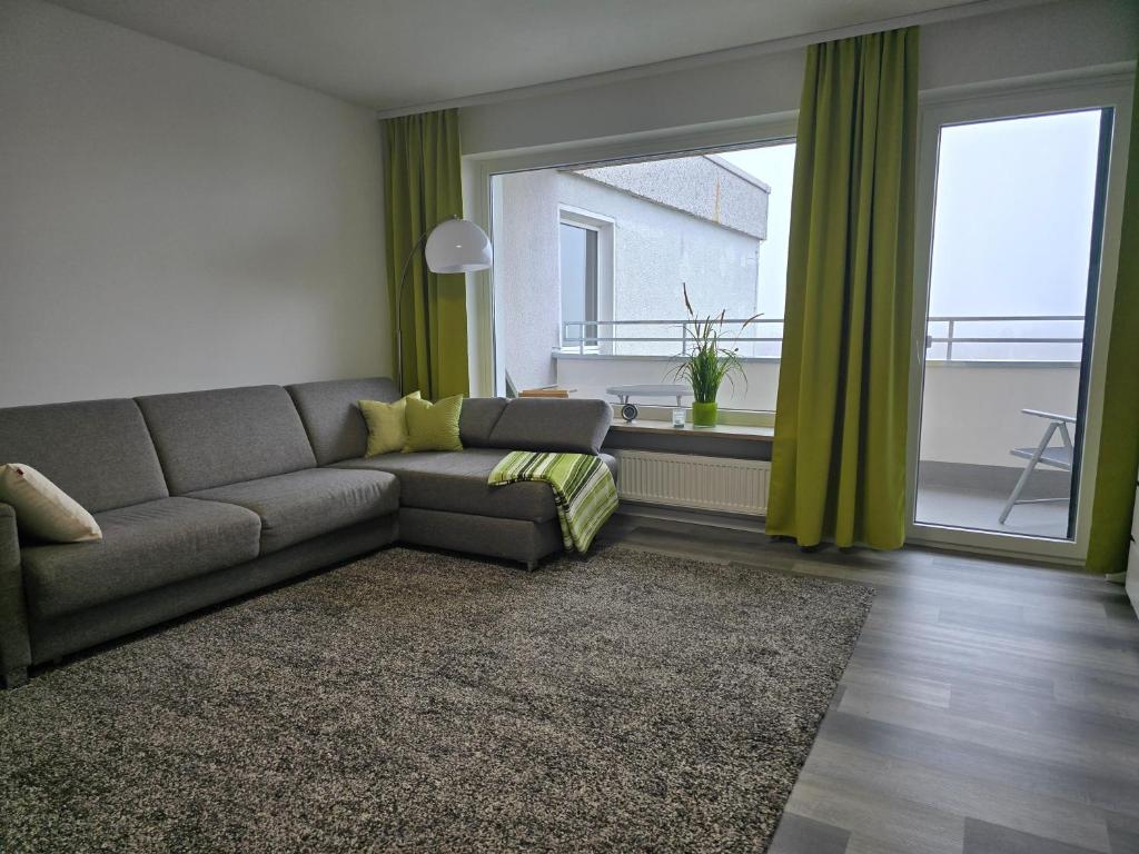 a living room with a couch and a large window at 1 Zimmer Wohnung Laatzen nähe Messe in Hannover