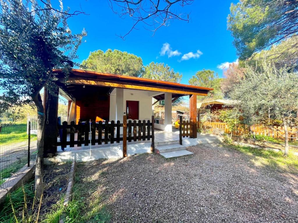 a small house with a wooden fence around it at Sea Breeze Home in Lotzorai