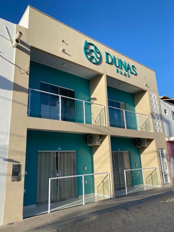 a building with a dung piles sign on it at Dunas Flat in Galinhos