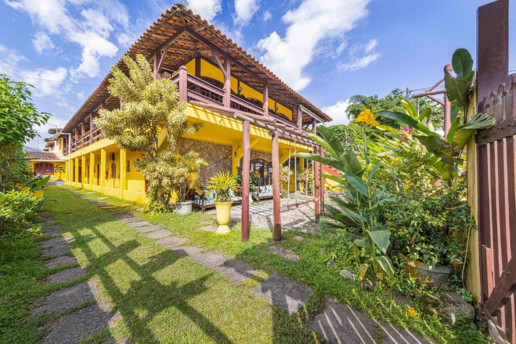 an exterior view of a yellow house with plants at Pousada Acqua Marina in Paraty
