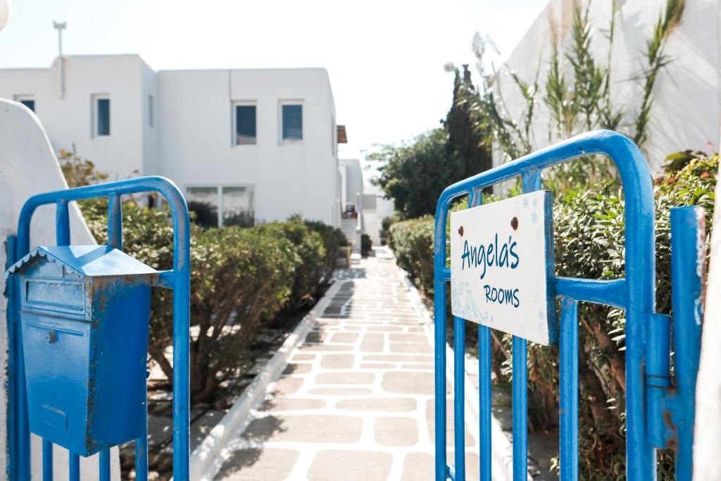 a sign on a blue rack on a street at Angela's Rooms in Mýkonos City