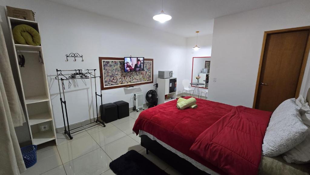 a bedroom with a red bed with a red blanket at Apto Girassol in Monte Verde