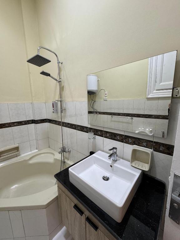 a bathroom with a sink and a mirror and a tub at Cairo Hub in Cairo