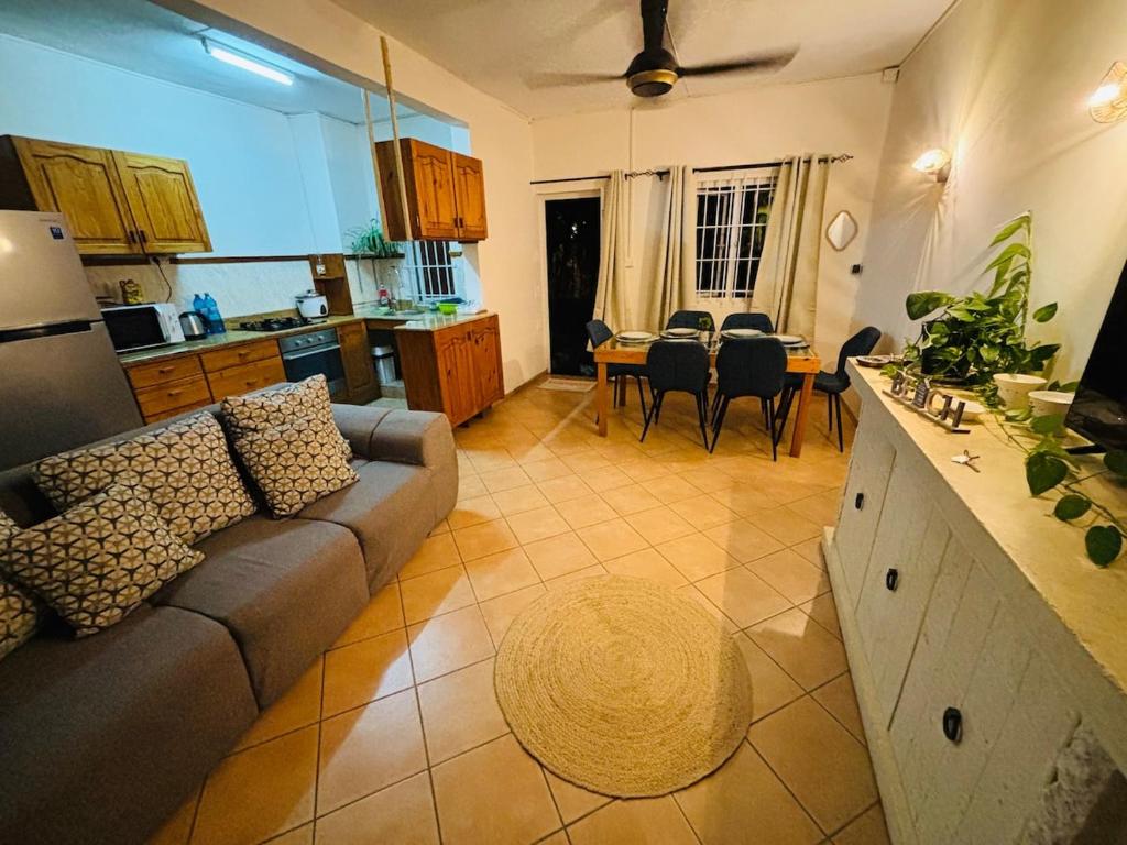 a living room with a couch and a table with chairs at Cosy duplex in Res les Barachois 3,Grand-Gaube in Grand Gaube