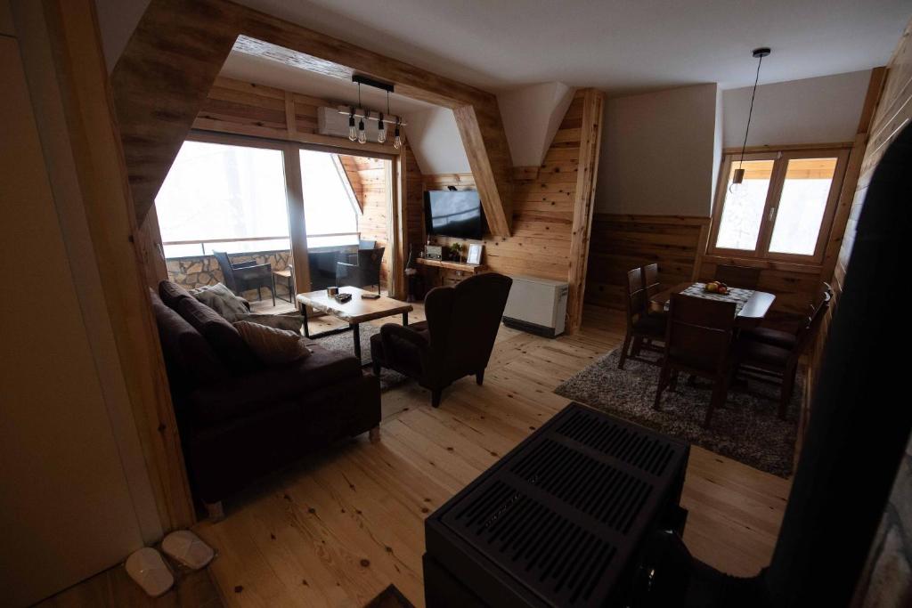 a living room with a couch and a table at Apartman Crni bor 2 Tara in Kaludjerske Bare
